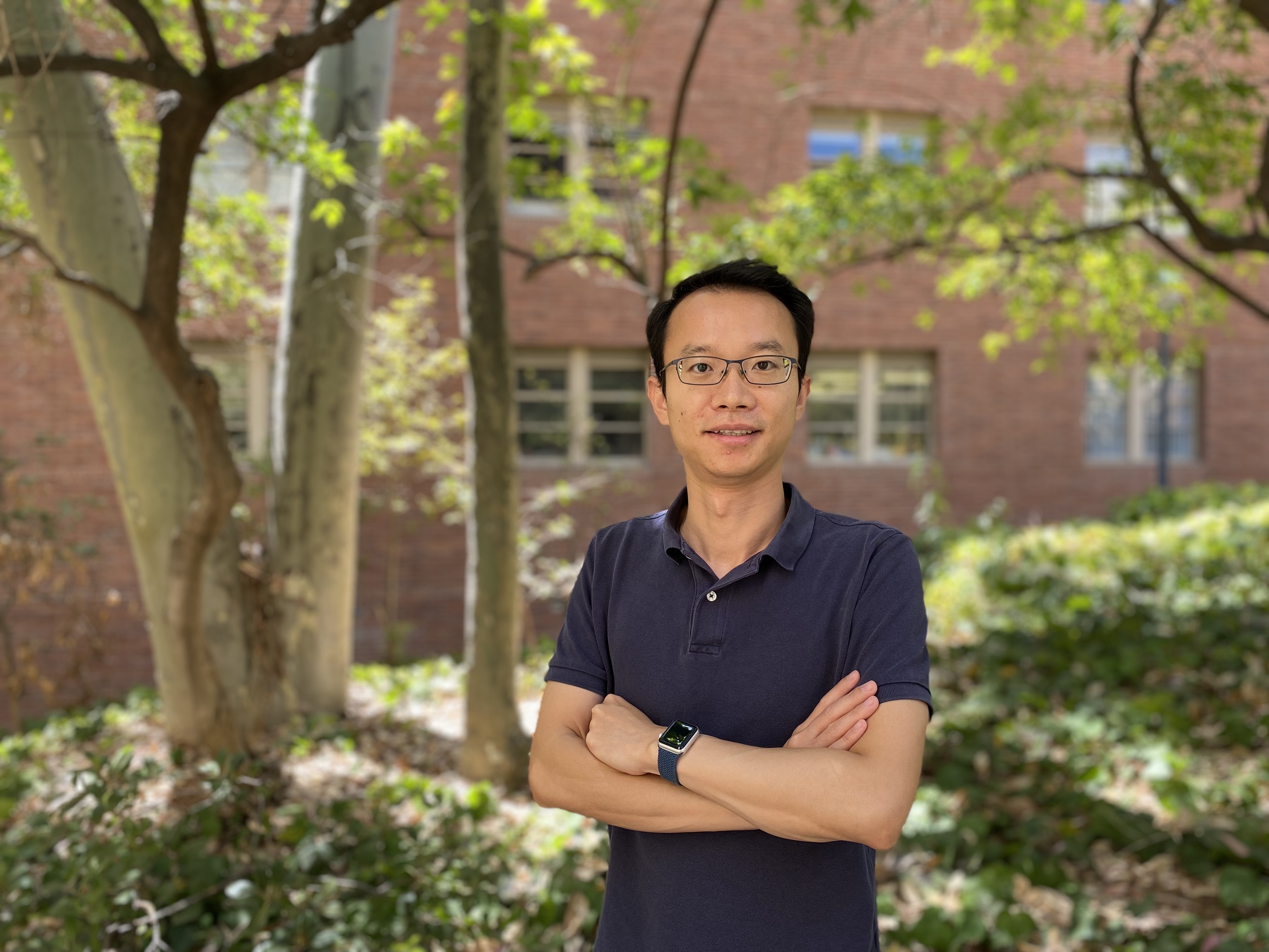 EPSS Assistant professor, Hao Cao standing with arms crossed in front of trees at UCLA